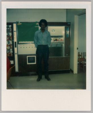 [Man standing in front of vending machines]
