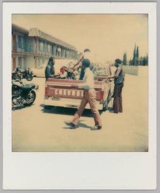 [Men loading motorcycles into Chevrolet truck]
