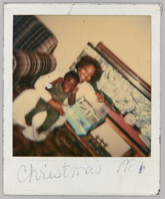 Christmas 1986 [Woman holding little boy and gift]
