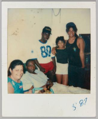 87 [Three adolescents with man and woman eating TV dinner]
