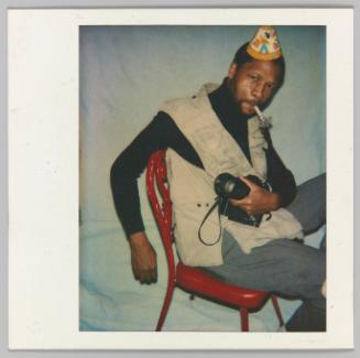 [Man with party hat and party horn holding camera]
