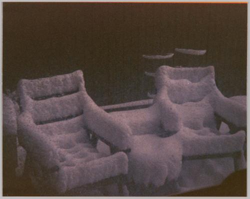 [Two patio chairs covered in snow]