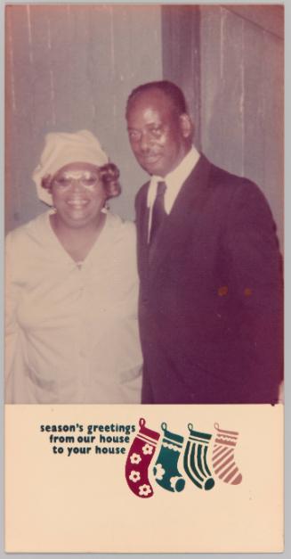 Season's greetings from our house to your house [Christmas card with image of man in suit with woman in hat, dress and glasses standing and smiling together]