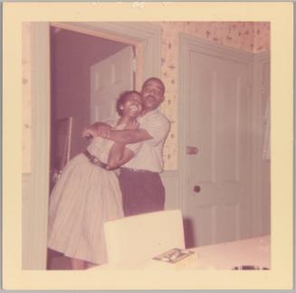 [Man with arms around woman as she laughs]
