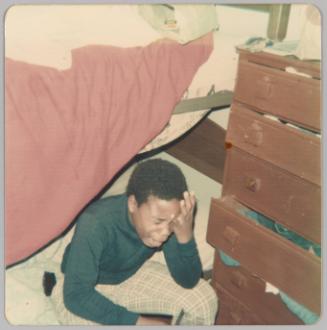 [Little boy sitting on bottom bunk crying with head in hands]
