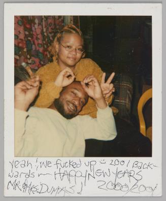 Yeah! We fucked up [smiley face] 2001 Backwards Happy New Years Mr & Mrs Dumas! 2000/2001 [Man with cigar leaning back on woman in yellow sweater, they are trying for form "2001" with their hands]