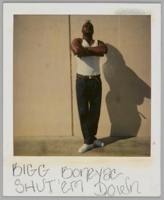 Bigg Boneyac Shut 'em Down [Man in white tank top and jeans standing with his arms crossed and looking down at camera]