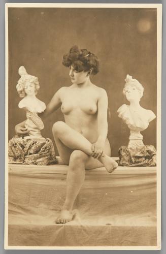 [Woman seated with sculptural busts]