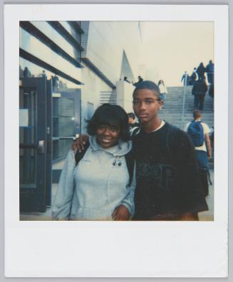 [Adolescent boy with arm around girl wearing a grey hoodie]