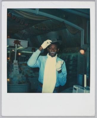 [Young man dressed up with white gloves and grey moustache]