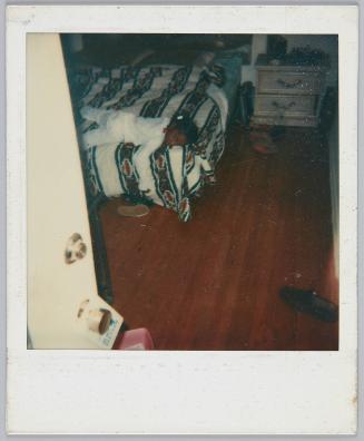 [Little girl laying flat on her stomach with arm dangling from bed]