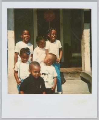 [Group of six small children smiling on front steps]