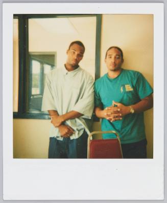 [Two young men posing, young man on right wearing green tshirt]