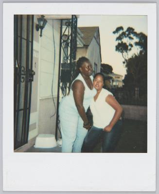 [Two women on porch, woman on left wears matching blue top and pants]