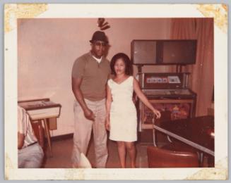 [Man and woman standin near jukebox, both their eyes are closed]
