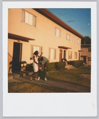 [Woman and man on front lawn, man has his shorts pulled down around ankles]
