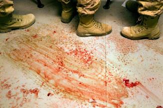 Canadian medics at a Canadian Forward Operating Base are seen standing on a blood stained floor while treating four Afghan civilians one of which later died from his wounds after they suffered injuries from an apparent improvised Explosive Device (IED) in Zhari District Afghanistan. Zhari and the adjacent Panjwai District have been the most volatile area of Afghanistan over the past two years and the site of NATO's largest ever land battle. Soldiers felt that the civilians' injuries seemed more associated with an accident from setting an IED than stumbling across one