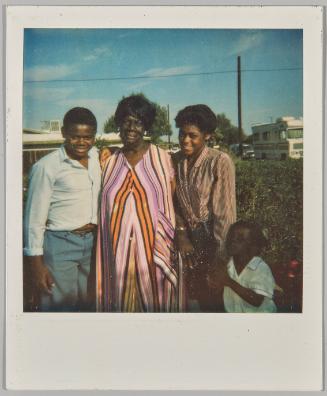[Two women sitting on cream/yellow couch, woman in pink sits on armchair in background]
