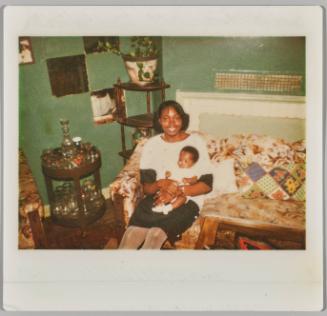 [Woman sitting on couch with baby in her lap]
