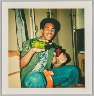 [Young man pouring drink into red glass]
