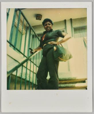 [Woman on exterior staircase with hand on hip, holding handbag]
