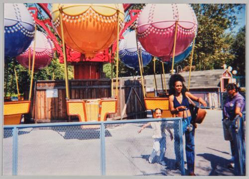 [Woman and child in front of amusement park ride]