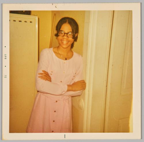 [Adolescent girl in glasses and baby pink outfit with arms crossed]

