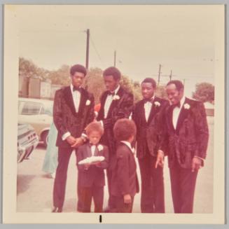 [Four men and two boys in suits with white corsages] 
