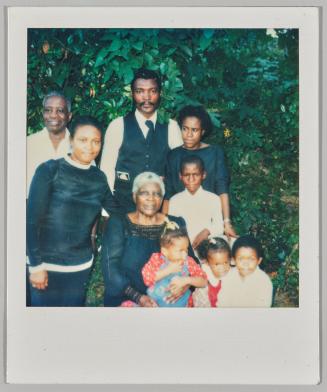 [Family with four children posing as a group in front of greenspace]
