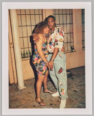 [Man and woman embracing with beers on window sill in background]
