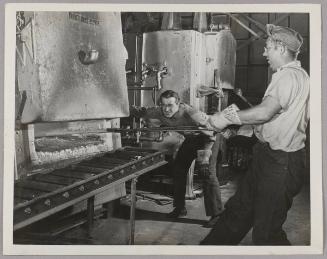 Two men processing steel at a Pennsylvania mill.