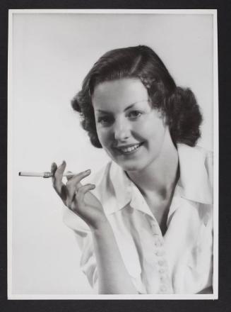 Woman smoking - brown hair, white shirt.