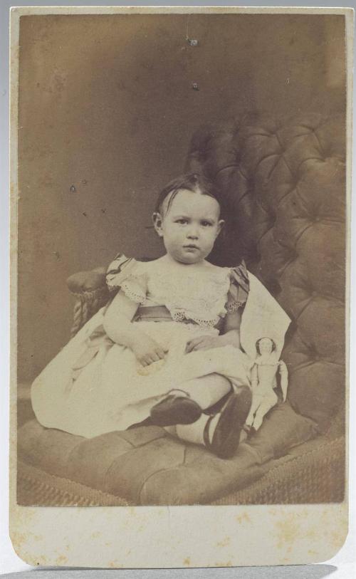 Young girl seated with a doll