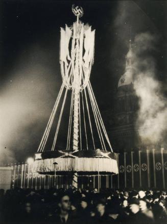 On the eve of the National May Day Holiday, peasants in traditional dress dance around the May-tree at Lustgarten, Berlin, illuminated by the light of open fires.