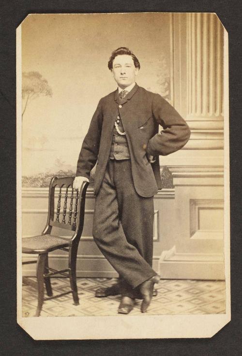 Unknown sitter [portrait of a standing man with a chair]