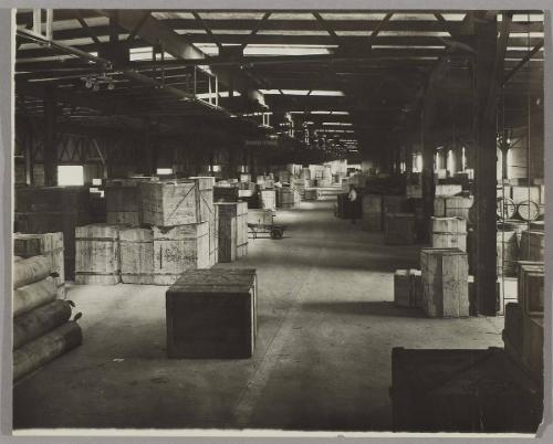 [Warehouse with rows of stacked crates]