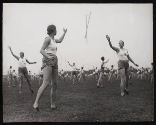 Sports day girls throwing batons to each other.