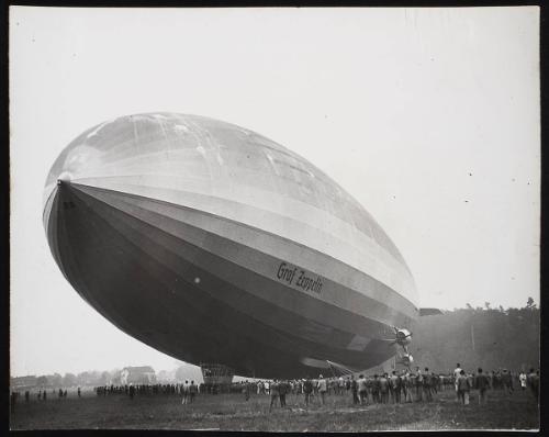 Nazi 'Graf' zeppelin with crowd of people underneath it.