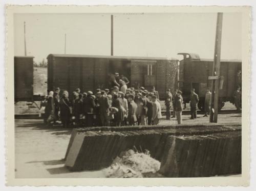 Ghetto police assisting resident onto deportation train at Radogoszcz Station
