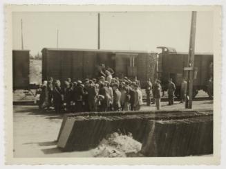 Ghetto police assisting resident onto deportation train at Radogoszcz Station