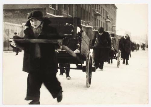 Young boy pulling cart with belongings through the ghetto in winter