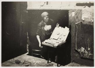 Woman street trading, with "Jude" stars [Stars of David] for sale