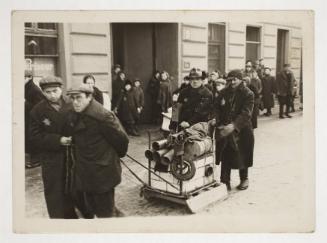 Three men moving a cart with scraps