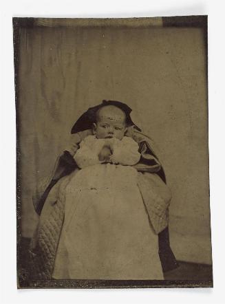 Portrait of baby in long white dress (seated on chair, background over-painted)