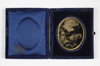 Portrait of baby with white bib (seated on lap of cropped figure)