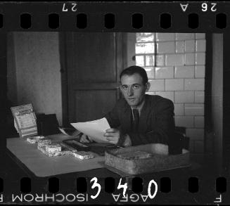 A member of the ghetto administration looking over documents at his desk