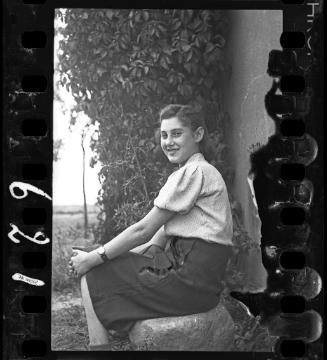 Young woman seated on a rock
