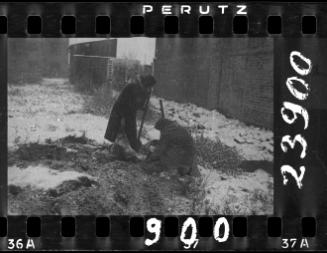 Two residents digging in the ground in winter