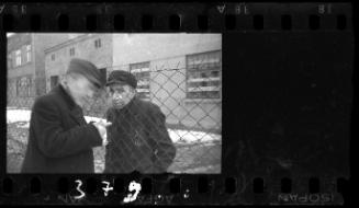 Men talking through prison fence