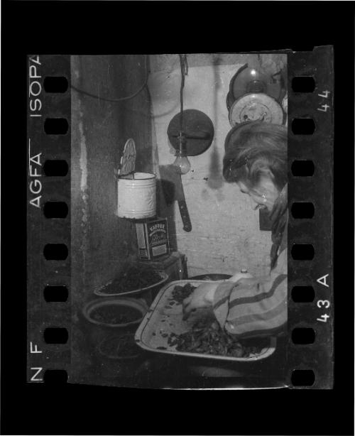 Elderly woman in the kitchen with food scraps